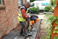 Vakmannen leggen geprint beton aan langs een woning